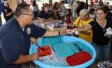 A Lemoore VIP passes out watermelon at Tuesday's National Night Out.